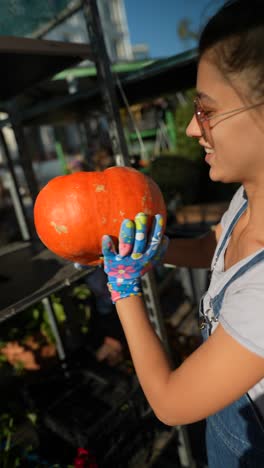 mujer recogiendo una calabaza en un mercado al aire libre