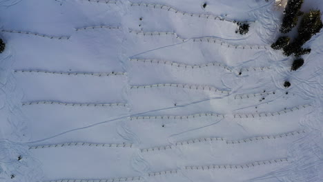 aerial view looking directly down, while lowering onto avalanche barriers in the french alps in winter