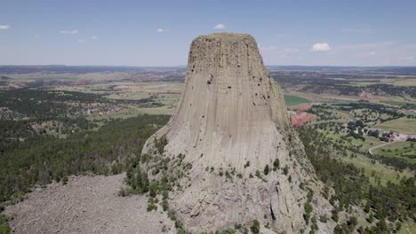 A-drone-shot-of-Devils-Tower,-a-massive,-monolithic,-volcanic-stout-tower,-or-butte,-located-in-the-Black-Hills-region-of-Wyoming