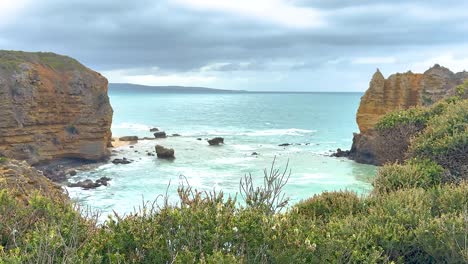 a serene coastal landscape with cliffs and ocean waves under cloudy skies, captured at great ocean road, australia