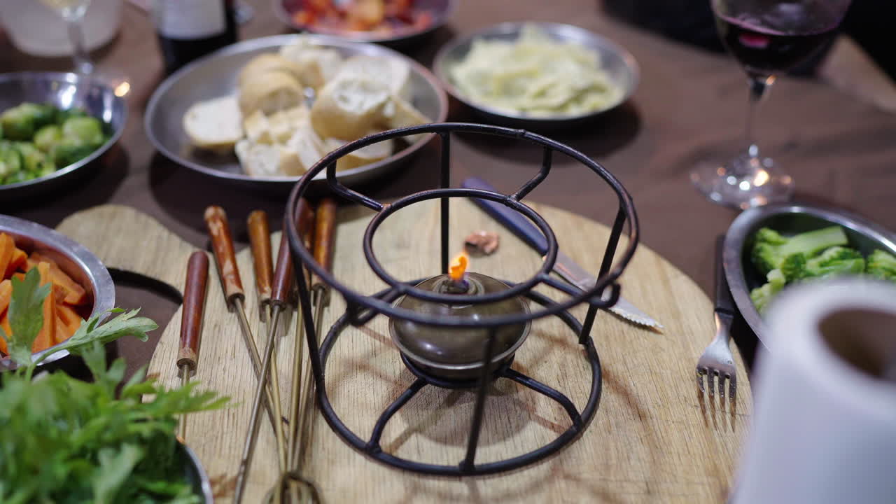 Tabletop heater for Argentine Bagna Cauda, surrounded by traditional vegetables, bread and wine
