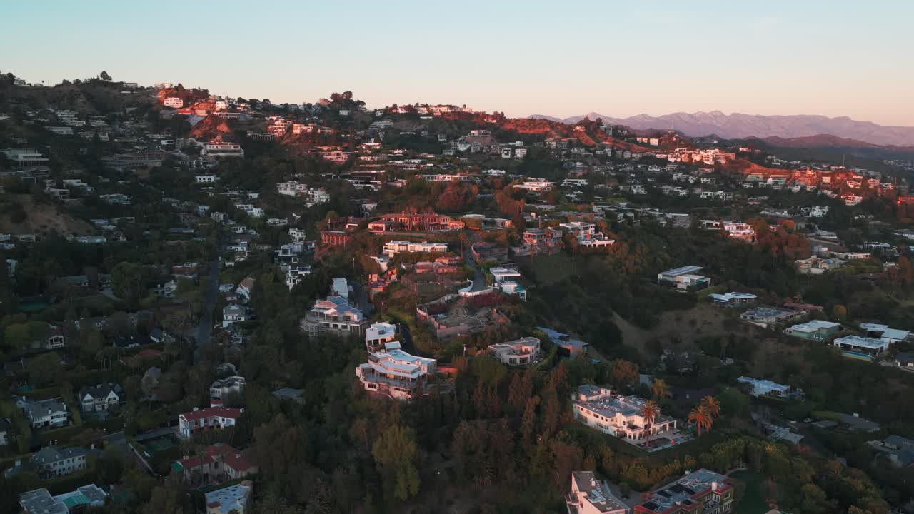 Ampia ripresa aerea in allontanamento di ville e tenute a Hollywood Hills al tramonto a West Hollywood, California. 4K.