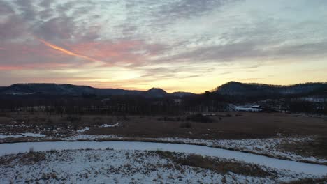 amanecer de invierno sobre colinas y campos