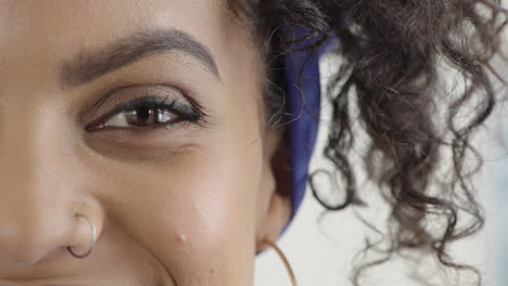 cerca de la mujer hispana ojo mirando feliz sonriendo usando anillo de nariz maquillaje cosméticos