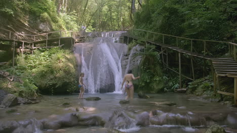 wooden walkways and waterfall in a lush forest