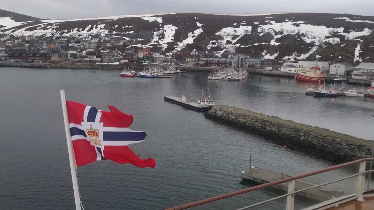 The flag of the Norwegian Coastal Express ships, docked in a Norwegian fishing village
