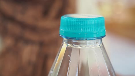 mano abriendo una botella de agua