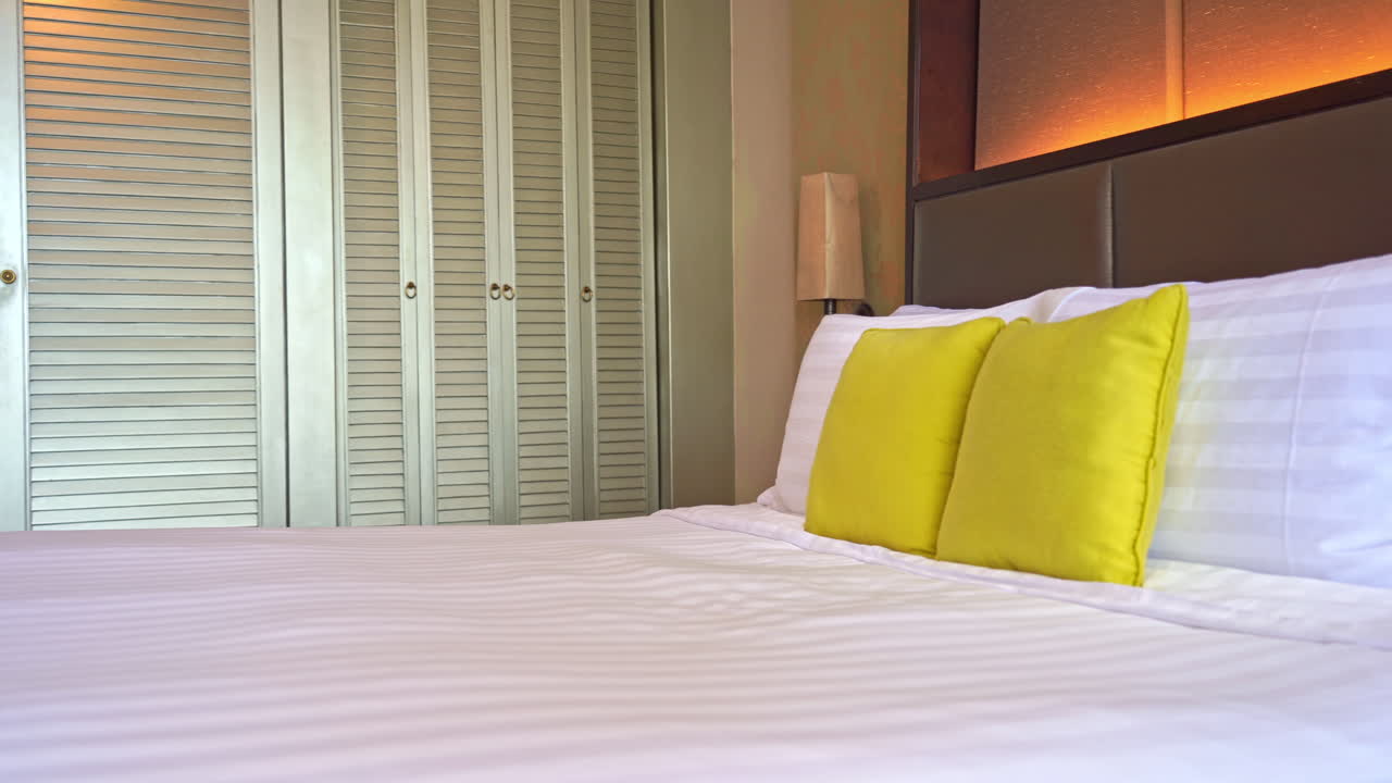 침대 발에서 침대 머리에 놓인 노란색 장식 베개까지 팬