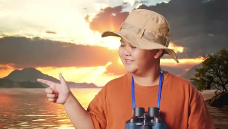 asian boy with a hat and binoculars smiling and pointing to side at a lake. boy researcher examines something, travel tourism adventure concept, close up