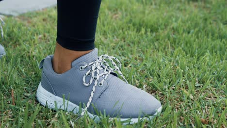 persona atando cordones de zapatos en el jardín 4k