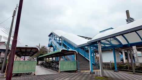 outdoor view of bike shelter and stairs leading to platform at kii katsuura station, in japan