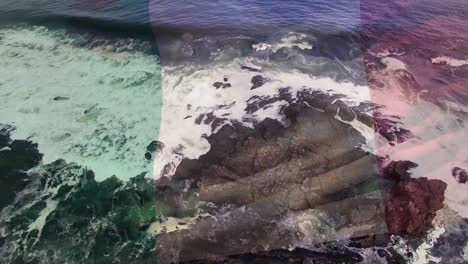 Digitale-Komposition-Der-Wehenden-Italienischen-Flagge-Gegen-Meereswellen,-Die-Auf-Die-Felsen-Schlagen