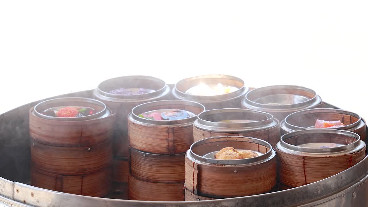 활기찬 푸켓 시장에서 증기되는 섬 바구니의 활기찬 전시, 전통적인 태국 요리 문화를 선보입니다.