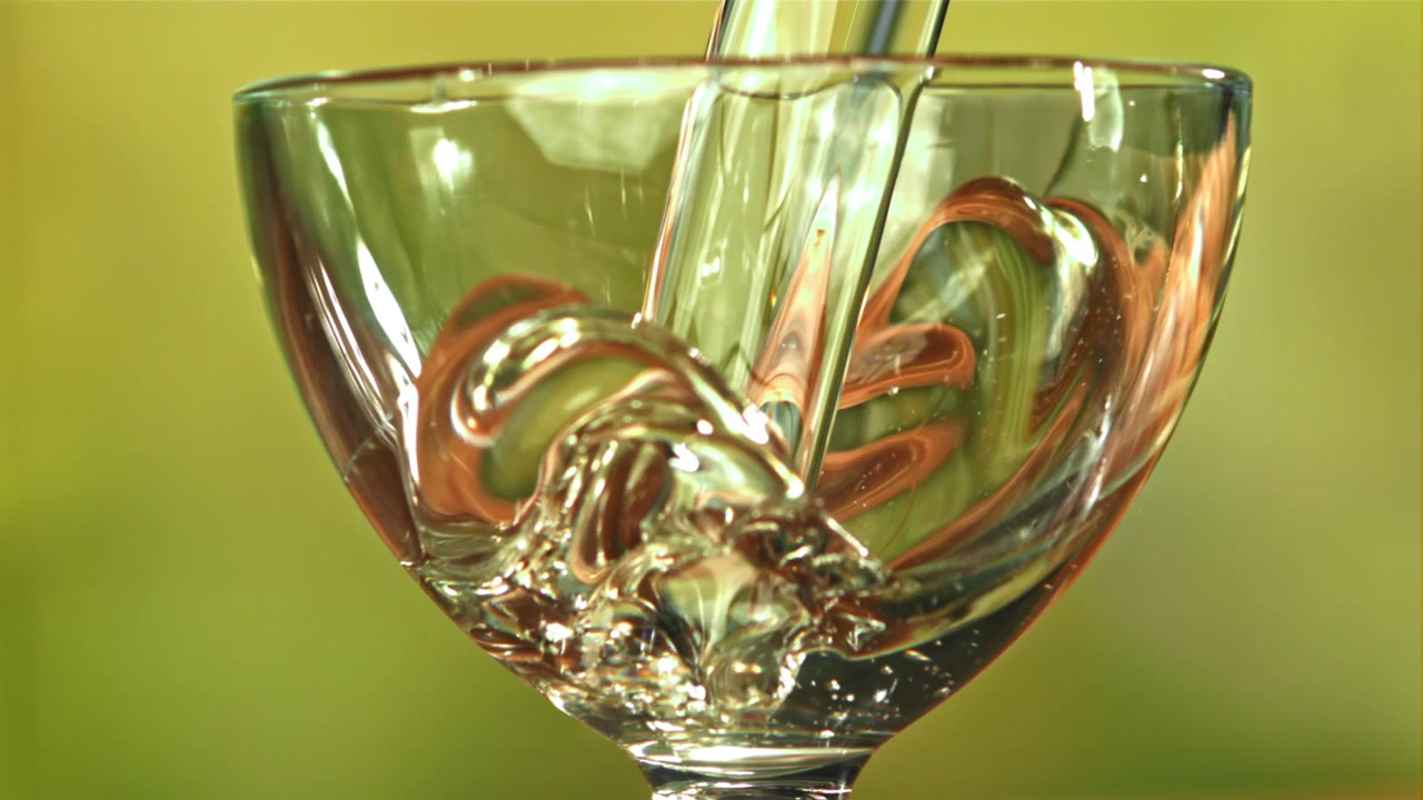 Liquido trasparente che si versa in un bicchiere al rallentatore