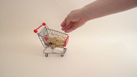 poner monedas a mano en un carrito de compras