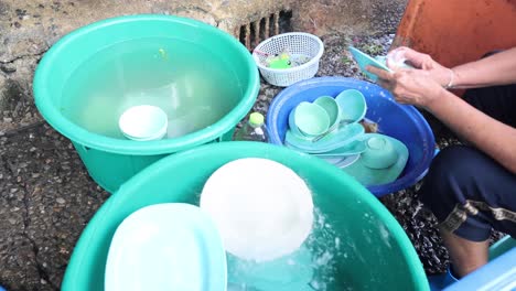 two people collaboratively washing dishes outside