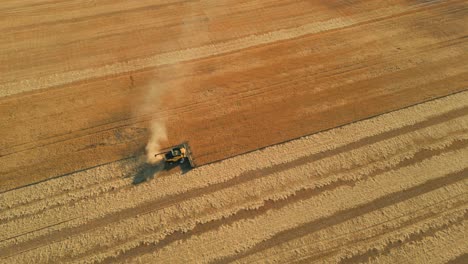 Disparo-De-Un-Dron-Alrededor-De-Una-Cosechadora-En-Un-Campo-De-Trigo-Que-Revela-El-Parque-Nacional-De-Stirling-Y-El-Paisaje-Al-Fondo,-En-El-Oeste-De-Australia