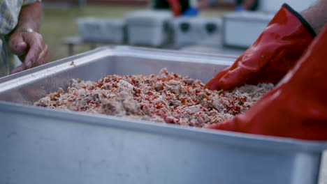 Tight-shot-of-mixing-pulled-pork-BBQ-with-vinegar-base-sauce