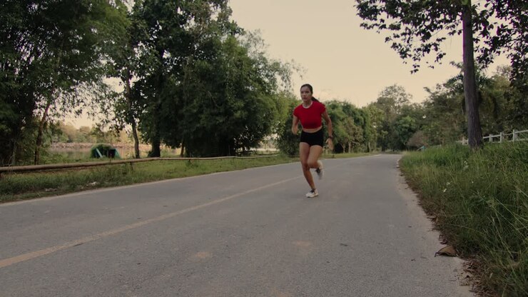 Donna che corre su una strada di campagna