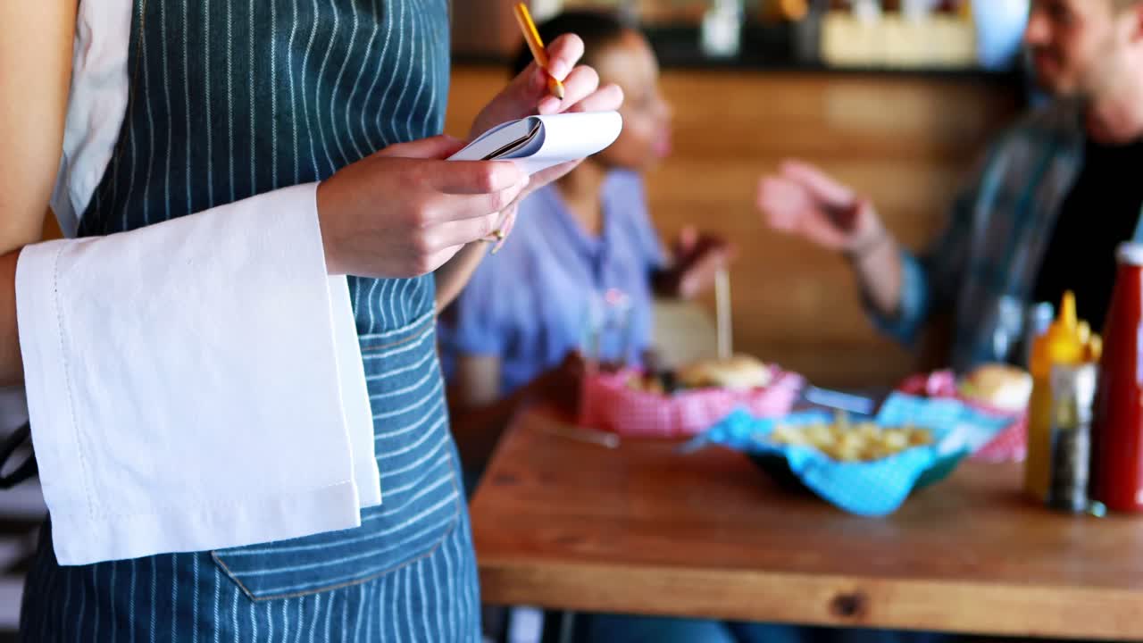 Cameriera che prende l'ordinazione dai clienti