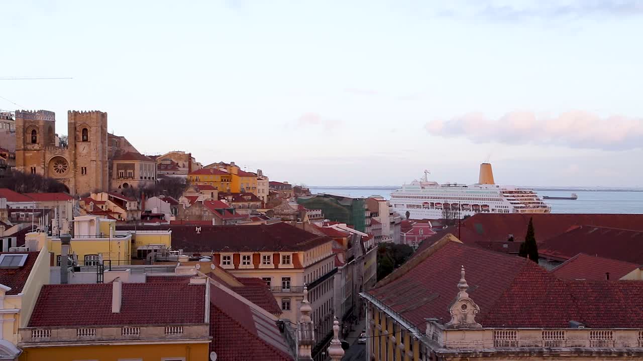 Sunset over buildings and cruise boat in the Tagus river, in the center of Lisbon, Portugal.