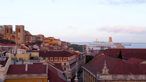 sunset over buildings and cruise boat in the tagus river, in the center of lisbon, portugal.