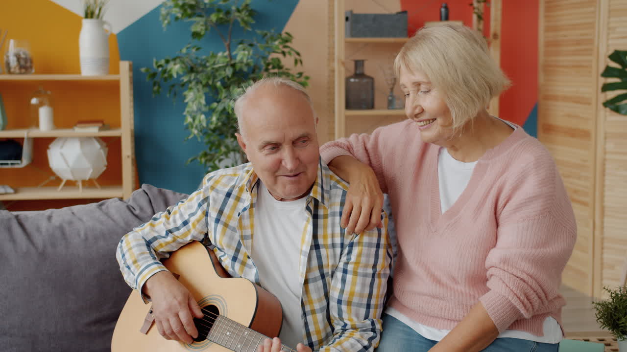Elderly Couple Singing and Playing Guitar at Home