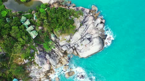 beautiful cliffs caved by turquoise sea water on shore of tropical island, beach cabins built on high rocks with panoramic ocean view