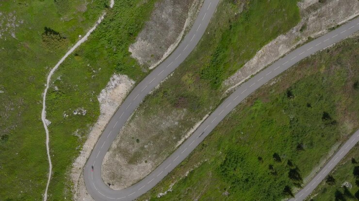 Riprese aeree cinematografiche con drone delle Alpi francesi che mostrano paesaggi montani mozzafiato, strade alpine tortuose, rigogliose valli verdi e ciclisti che attraversano scenari spettacolari. Perfetto per i viaggi.