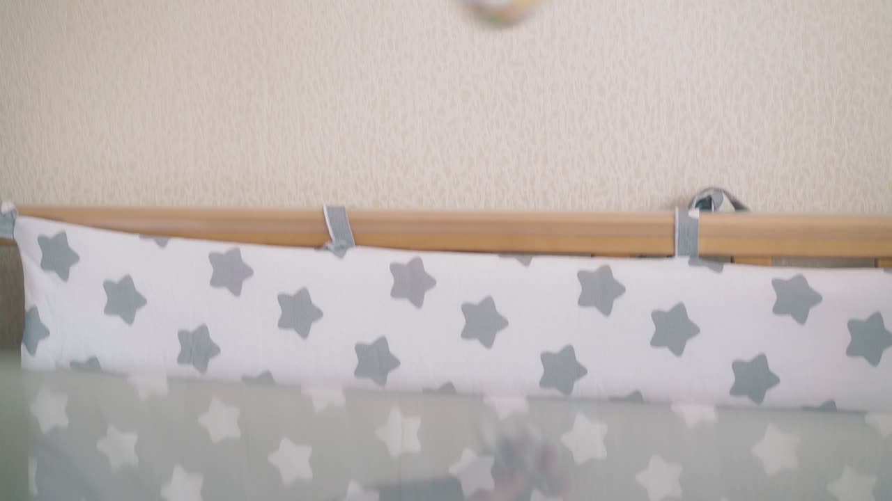 la mamma felice gioca con il neonato che mostra il sonaglio a casa