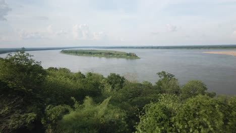 Die-Drohne-Fliegt-An-Der-Pagode-Am-Ufer-Des-Mekong-Vorbei-Und-Enthüllt-Eine-üppige-Insel-In-Der-Mitte-Des-Flusses