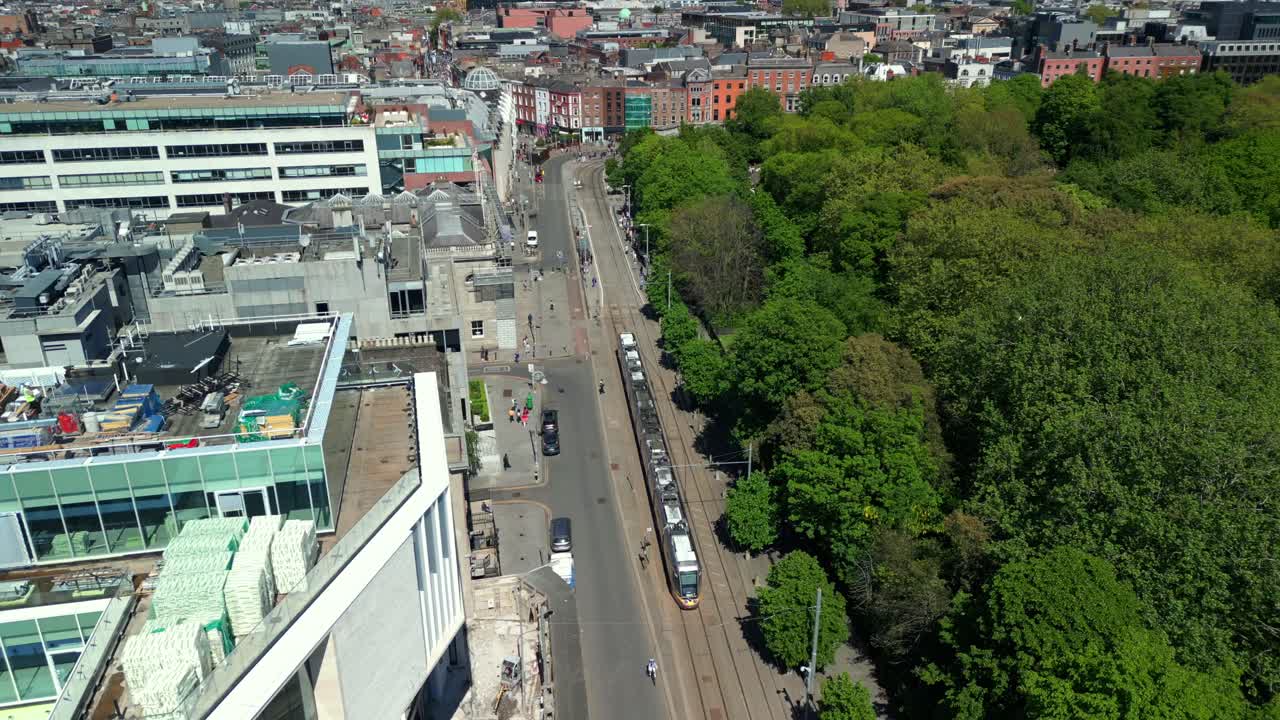 Aerial video of the Luas Tram System operating in Dublin City Centre, County Leinster, Ireland, on a bright and sunny day. Filmed in 4K next to St Stephen's Green, in 60FPS and with Rec709 color.