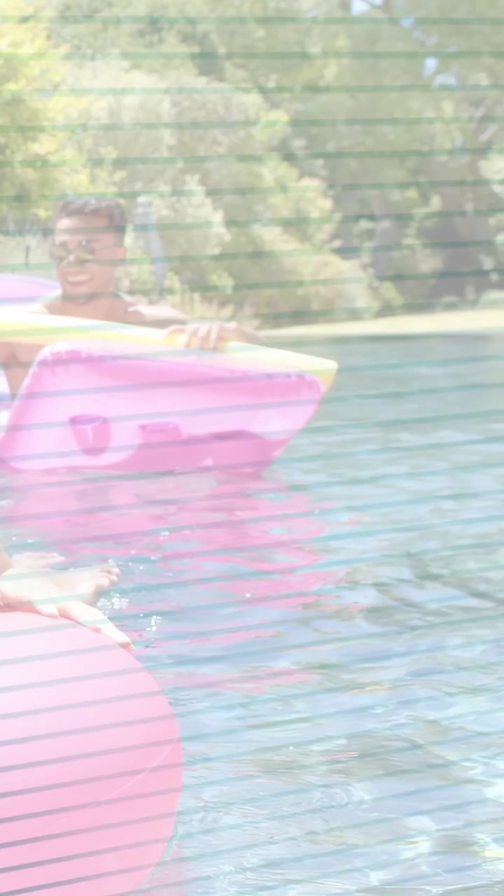 Vertical video: Man in shades lifting noodle moving float across pool leisure green tint overlay
