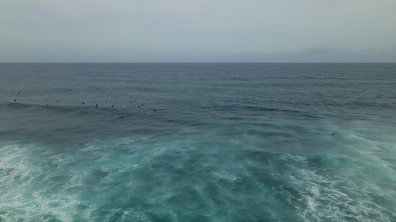 열대 섬 해안에서 큰 파도를 기다리는 서퍼 그룹의 공중 전망