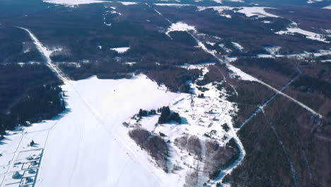 aerial view of a winter landscape with snow-covered forests and ski trails