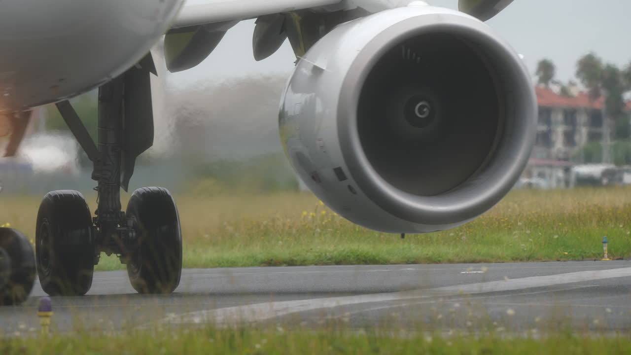 Close-up view of an aircraft engine and landing gear on a runway, highlighting engineering details and aviation design elements