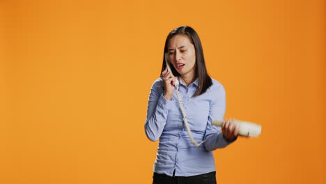 Asian-person-making-remote-call-on-landline-phone