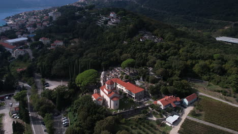 Aerial-View-of-Savina-Monastery-and-Graveyard-Above-Cityscape-of-Herceg-Novi,-Montenegro,-Revealing-Drone-Shot