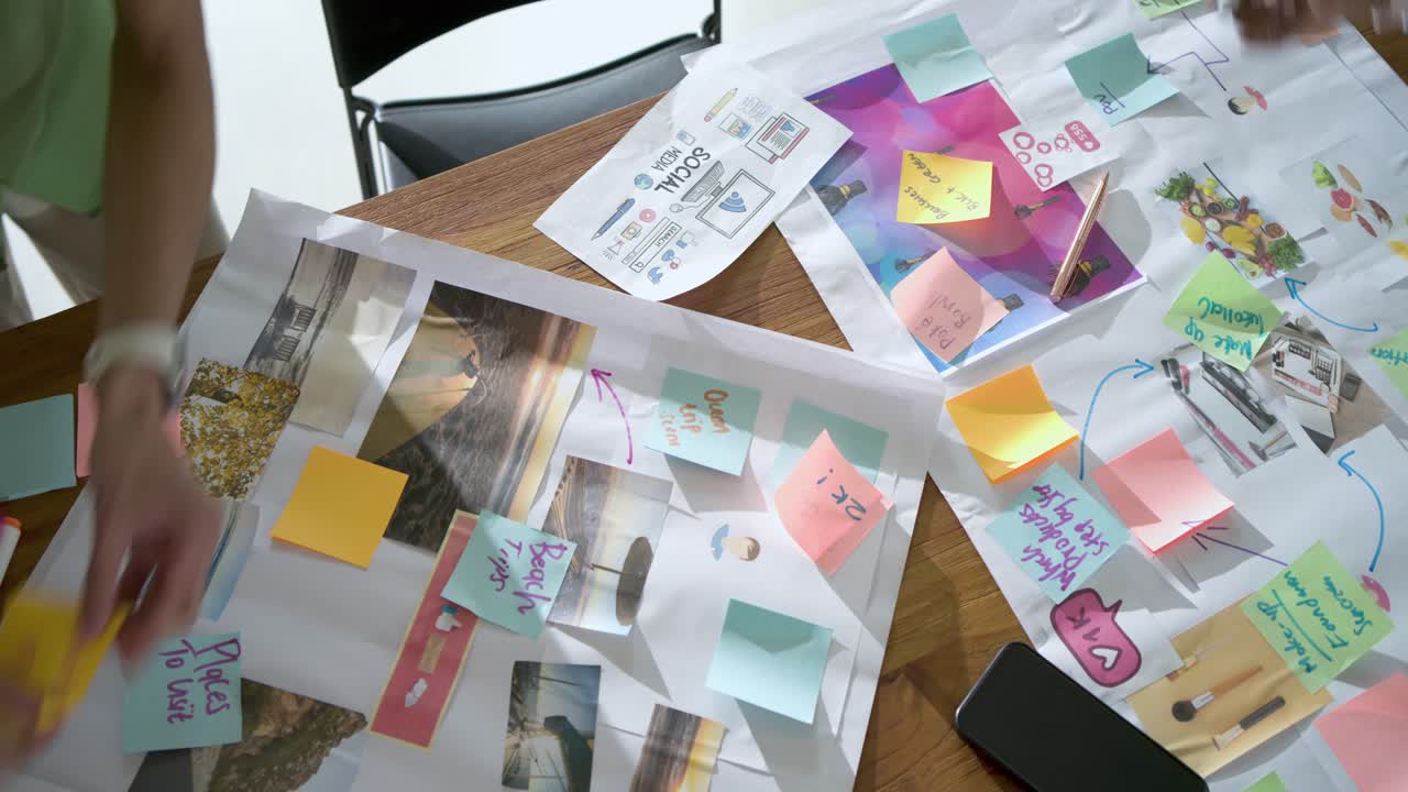 On start two hands are sketching arrows and arranging sticky notes on wooden board for planning