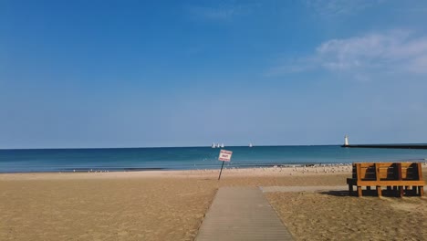 no lifeguard sign on a walkway an empty beach at sodus point new york vacation spot at the tip of land on the banks of lake ontario