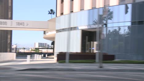 un automóvil viaja a lo largo de una calle en la ciudad del siglo los ángeles como se ve a través de la ventana lateral 1