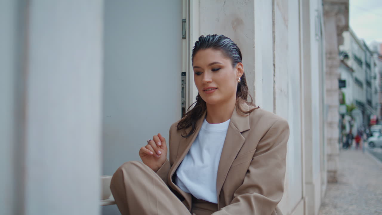 Ragazza alla moda che si rilassa in un caffè all'aperto, primo piano. Donna seduta in una caffetteria all'aperto