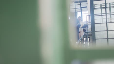 Happy-diverse-female-and-male-business-colleagues-discussing-work-at-office