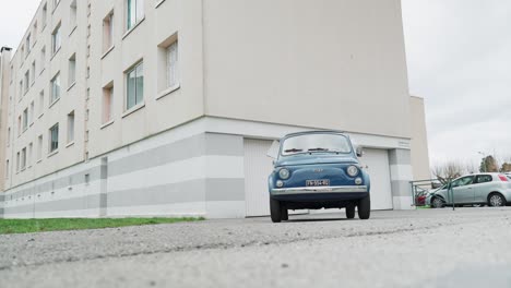 classic fiat 500 parked in front of apartment building