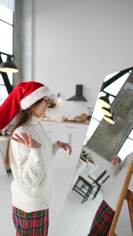mujer con sombrero de santa en una cocina moderna