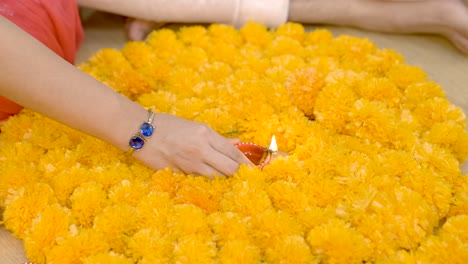 Indian-couple-decorating-home-with-Rangoli-and-Earthen-lamps