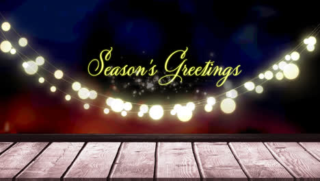 Animation-of-fairy-lights-and-seasons-greetings-text-over-wooden-boards