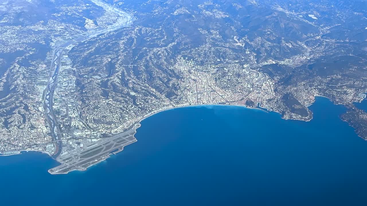 Veduta aerea elevata dell'aeroporto e della città di Nizza, scattata dalla cabina di pilotaggio di un jet che vola a 12000 m di altezza in una soleggiata giornata invernale.