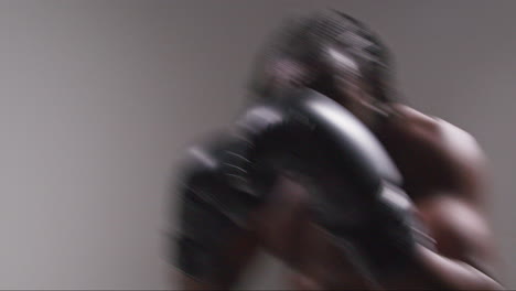 real time studio pov shot of male boxer wearing boxing gloves in boxing match punching towards camera