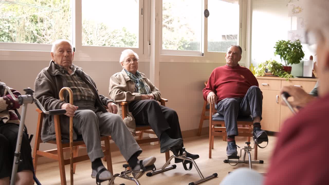 Senior people exercising with bike pedals in retirement home